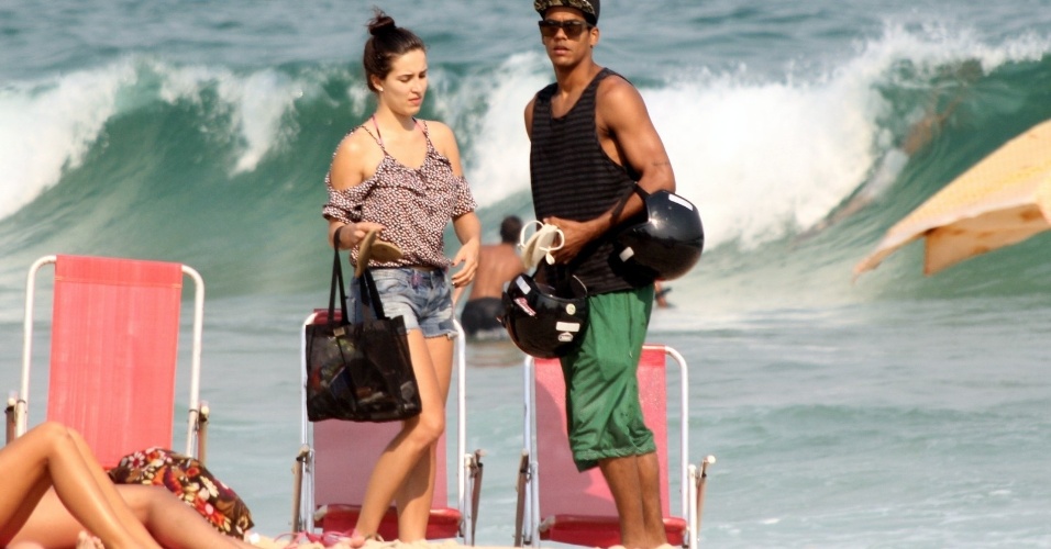 13.out.2014- Marcello Melo Jr. e Carolina deixaram a praia no final da tarde e deixaram o local segurando os capacetes 