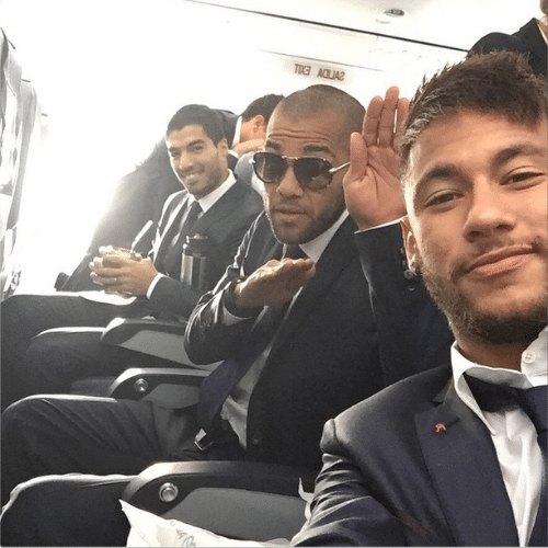 25.out.2014 - Neymar faz selfie vestindo terno ao lado dos jogadores do Barcelona Daniel Alves e Luis Suárez dentro de um avião na Espanha.