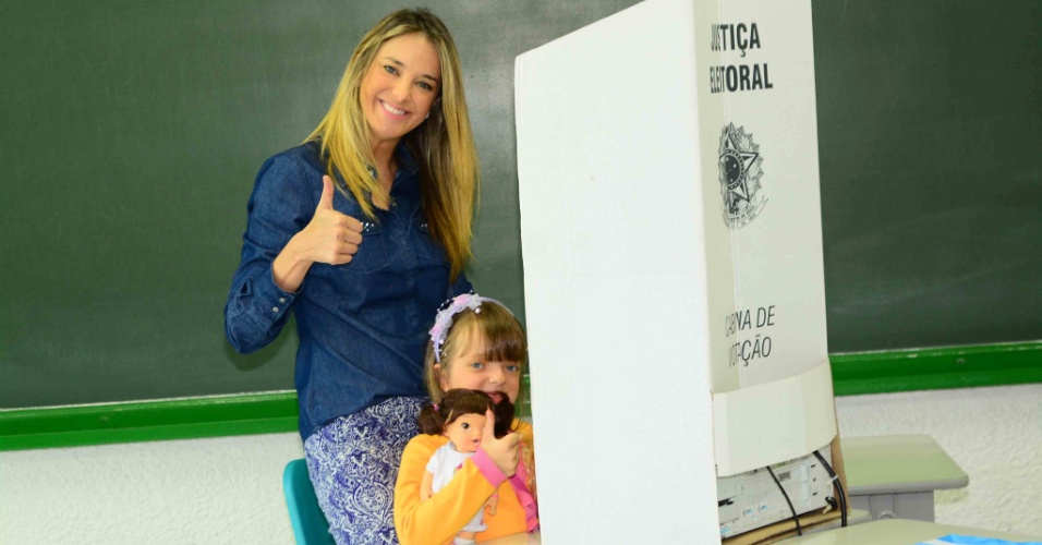 26.out.2014 - Ticiane Pinheiro leva a filha, Rafa Justus, à votação no colégio Palmares, em Pinheiros, São Paulo.