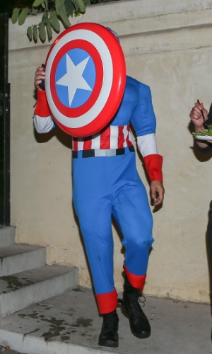 24.out.2014 - Gerard Butler fez graça e se esconde atrás de seu escudo de Capitão América ao chegar à festa anual de Halloween Casamigos, em Los Angeles