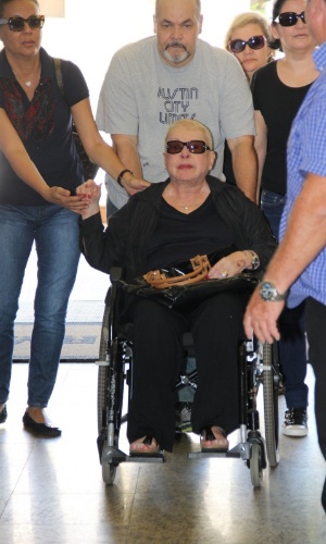 1.nov.2014- Bastante abalada, a mãe de Rafael Soares, Teresa Austregésilo chega para o velório do filho em uma cadeira de rodas e foi consolada por amigos e familiares