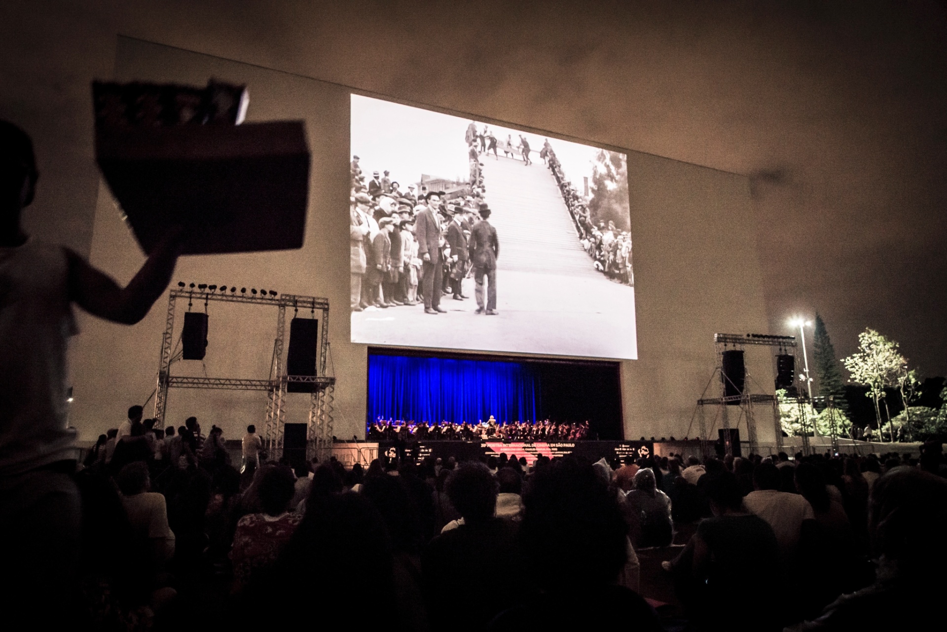 1°.nov.2014 - O longa "O Circo", de Charlie Chaplin, foi exibido gratuitamente no parque Ibirapuera, acompanhado pela Orquestra Experimental de Repertório da Fundação Theatro Municipal de São Paulo. A homenagem aos 100 anos do personagem Carlitos marcou o encerramento da Mostra Internacional de Cinema de São Paulo - Rafael Roncato/UOL