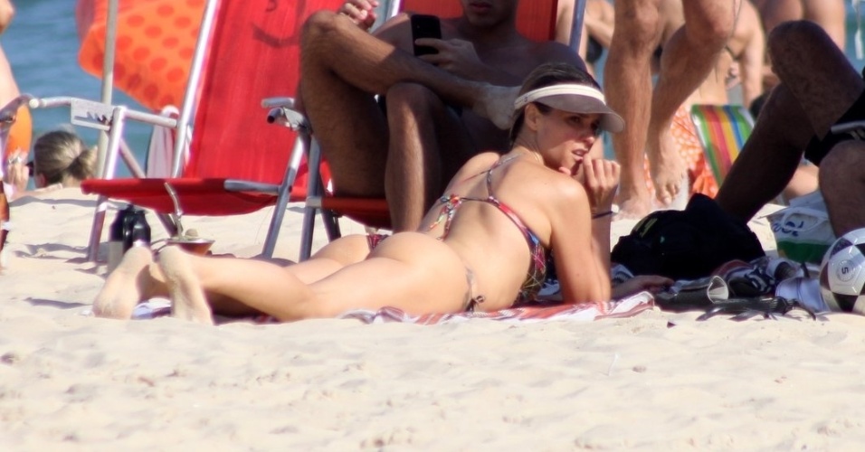 2.nov.2014 - Apresentadora Fernanda Lima se bronzeia na praia do Leblon, no Rio de Janeiro, e protege o rosto com um boné