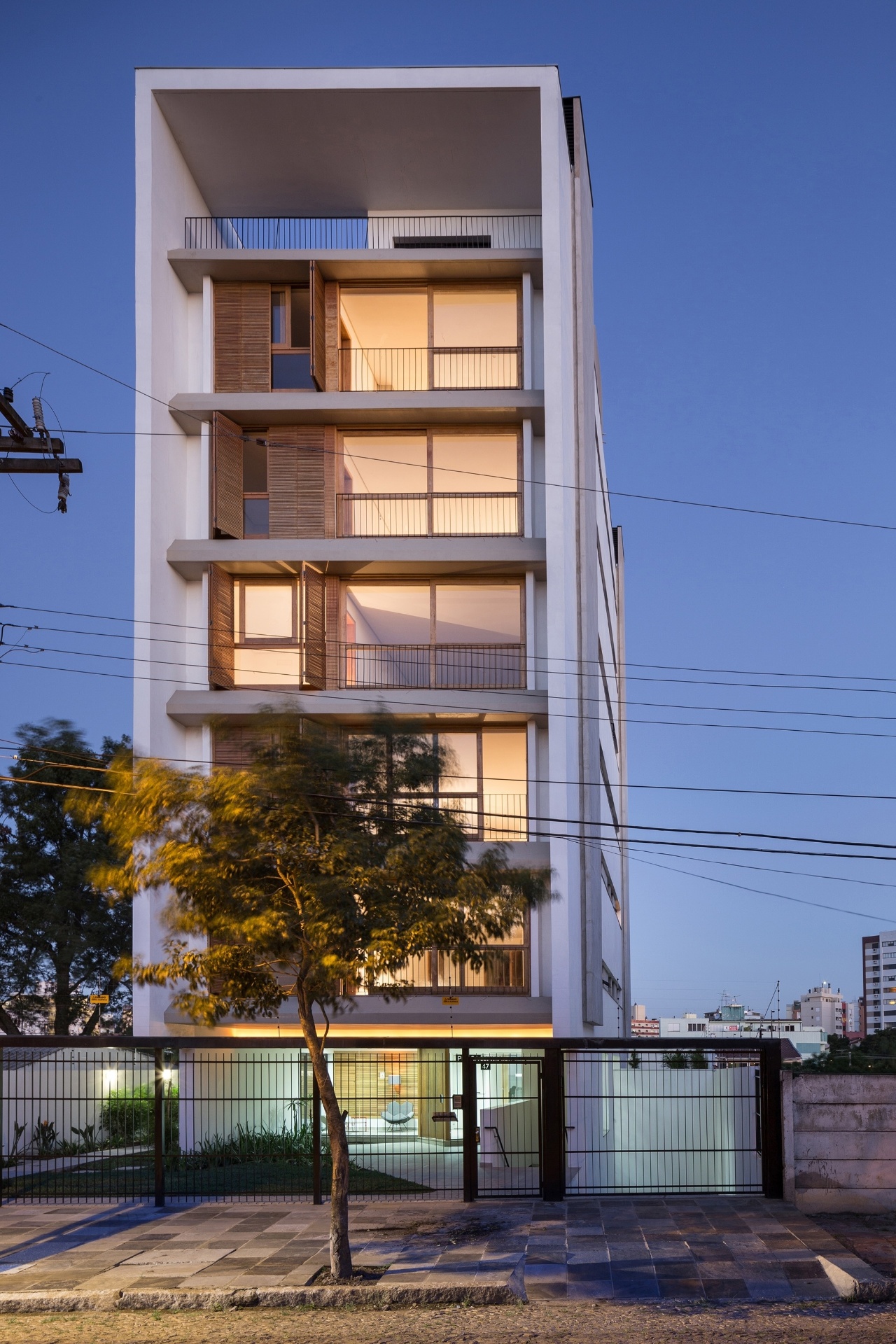 [FINALISTA] O Melhor da Arquitetura 2014 - categoria "Condomínios Residenciais": Edifício Praça Municipal 47 - Arquitetura Nacional. No projeto do edifício de 1.532 m², com cinco pavimentos, situado na capital gaúcha, o declive natural do terreno facilitou o posicionamento da garagem no subsolo. Na área social, as esquadrias de madeira com vidro ocupam todo o pé-direito de cada apartamento, reforçando a passagem de luz natural - Divulgação