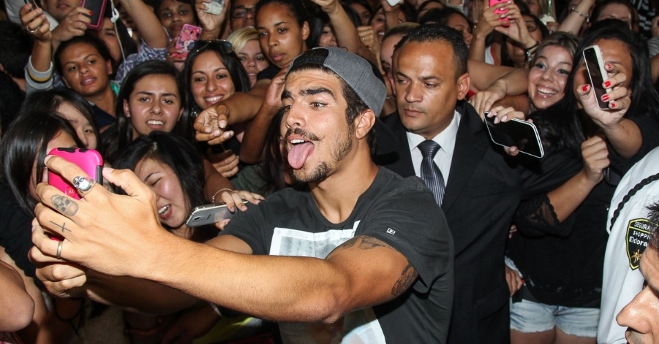 7.nov.2014- Caio Castro causa alvoroço e faz careta ao fazer selfie com fãs ao participar de evento no shopping Eldorado em São Paulo