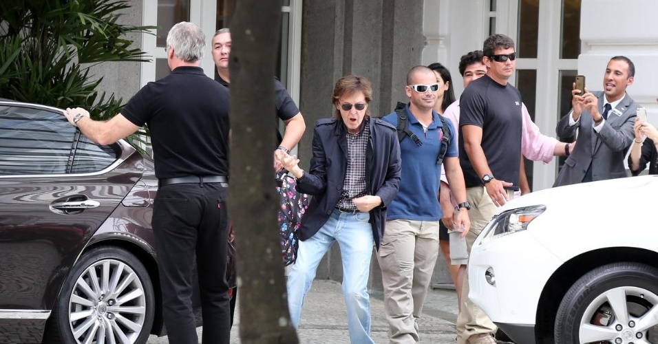 12.nov.2014 - Paul McCartney deixa hotel Copacabana Palace e acena para os fãs. Antes de entrar no carro que o levou para o show no HSBC, o ex-beatle ainda brincou com "air guitar" na frente do hotel