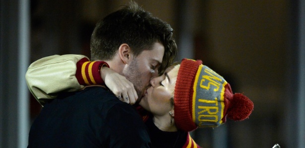 Miley Cyrus troca beijos com filho de Arnold Schwarzenegger durante jogo