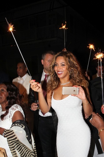 16.nov.2014 - Com celular na mão, Beyoncé curte a festa de casamento da irmã Solange, nas ruas de Nova Orleans