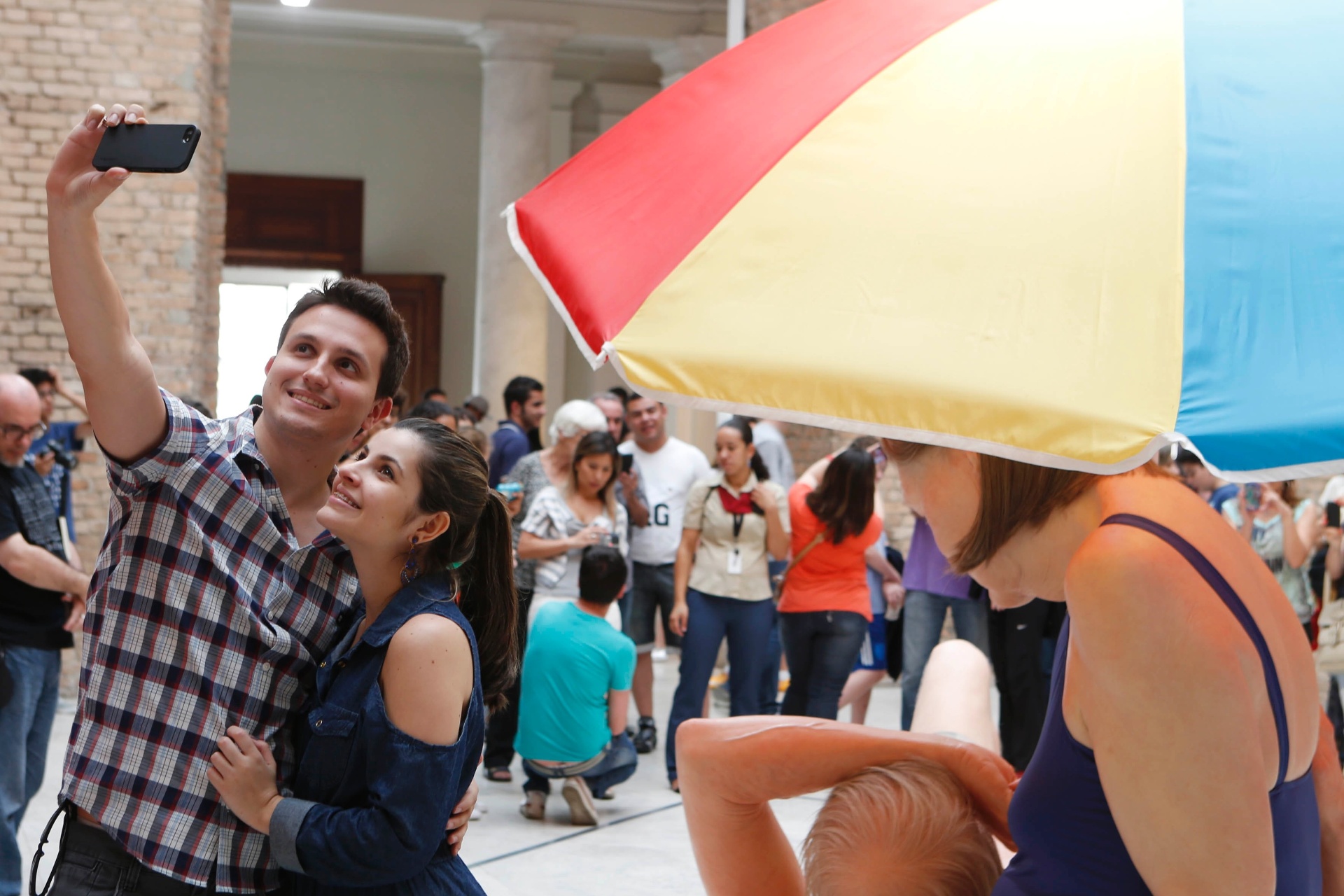 Público confere a exposição de Ron Mueck, na Pinacoteca de São Paulo. Com celulares, pessoas disputam espaço para fotografar as esculturas e fazer "selfies". Na foto, o casal Gustavo e Aline faz o seu autorretrato em frente à obra "Casal Debaixo do Guarda-sol" - Junior Lago/UOL