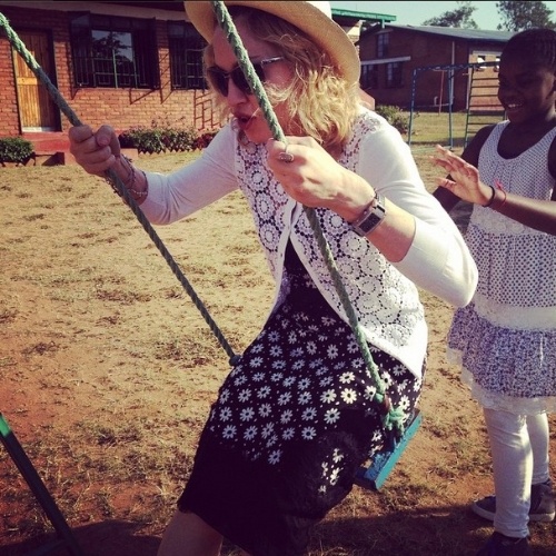 27.nov.2014 - Madonna brinca de balanço com a filha Mercy James no Malawi