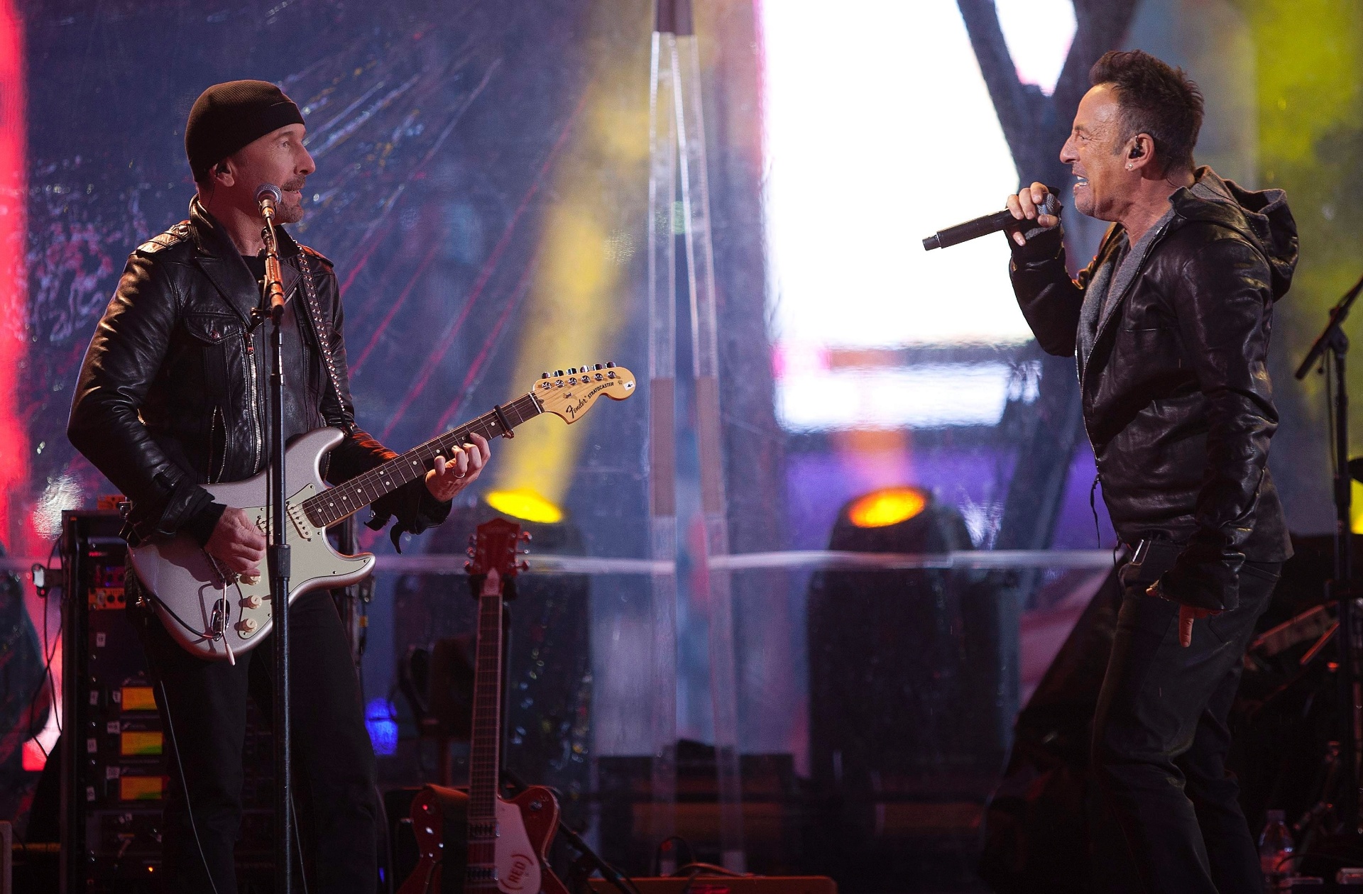 1.dez.2014 - Bruce Springsteen se junta aos membros do U2 Adam Clayton, The Edge e Larry Mullen Jr. para tocar as músicas do grupo, enquanto uma multidão enfrentava a chuva na Times Square, em Nova York, para assistir ao show surpresa - REUTERS/Carlo Allegri