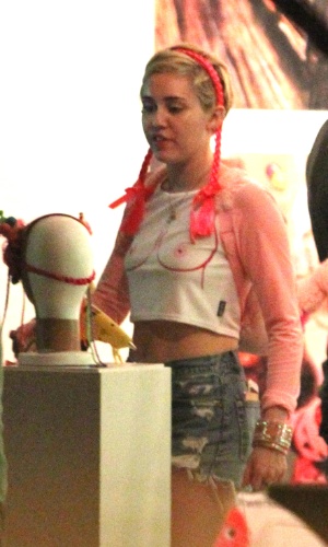 3.dez.2014 - Fotografada num intervalo entre os ensaios de sua turnê num hotel em Miami, a cantora americana Miley Cyrus chamou a atenção pela camiseta irreverente, com desenho de seios
