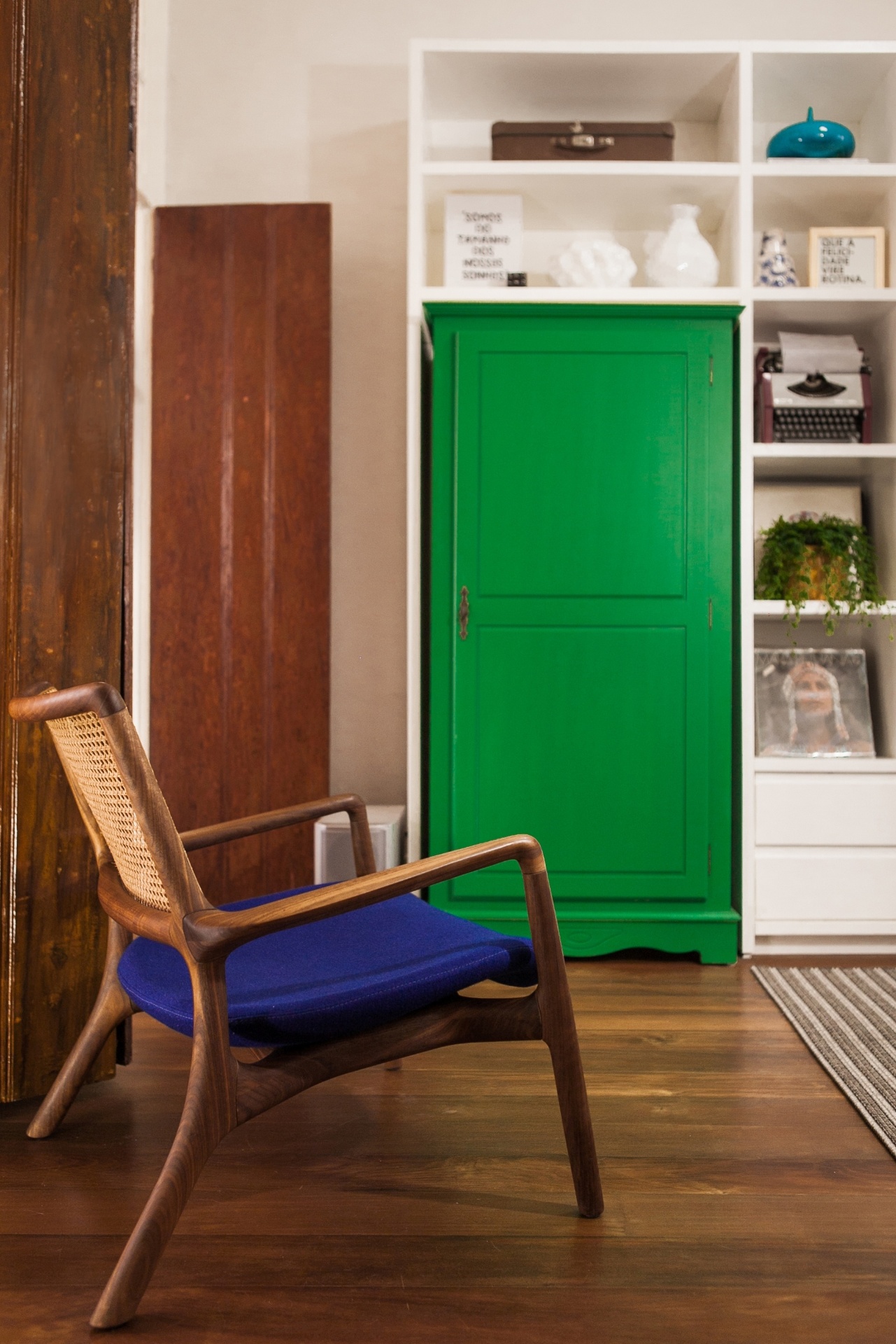 O armário de madeira é um móvel antigo do acervo da moradora do Sobrado 505, em Florianópolis (SC). A peça foi lixada e recebeu laca fosca verde. Destaque também para a poltrona Mad, de Jader Almeida. Nos nichos, os vasos brancos, o pote azul e os quadros são da Objeteria. Os projetos de reforma e interiores são do Studio UM - Mauri Cherobin/ Divulgação