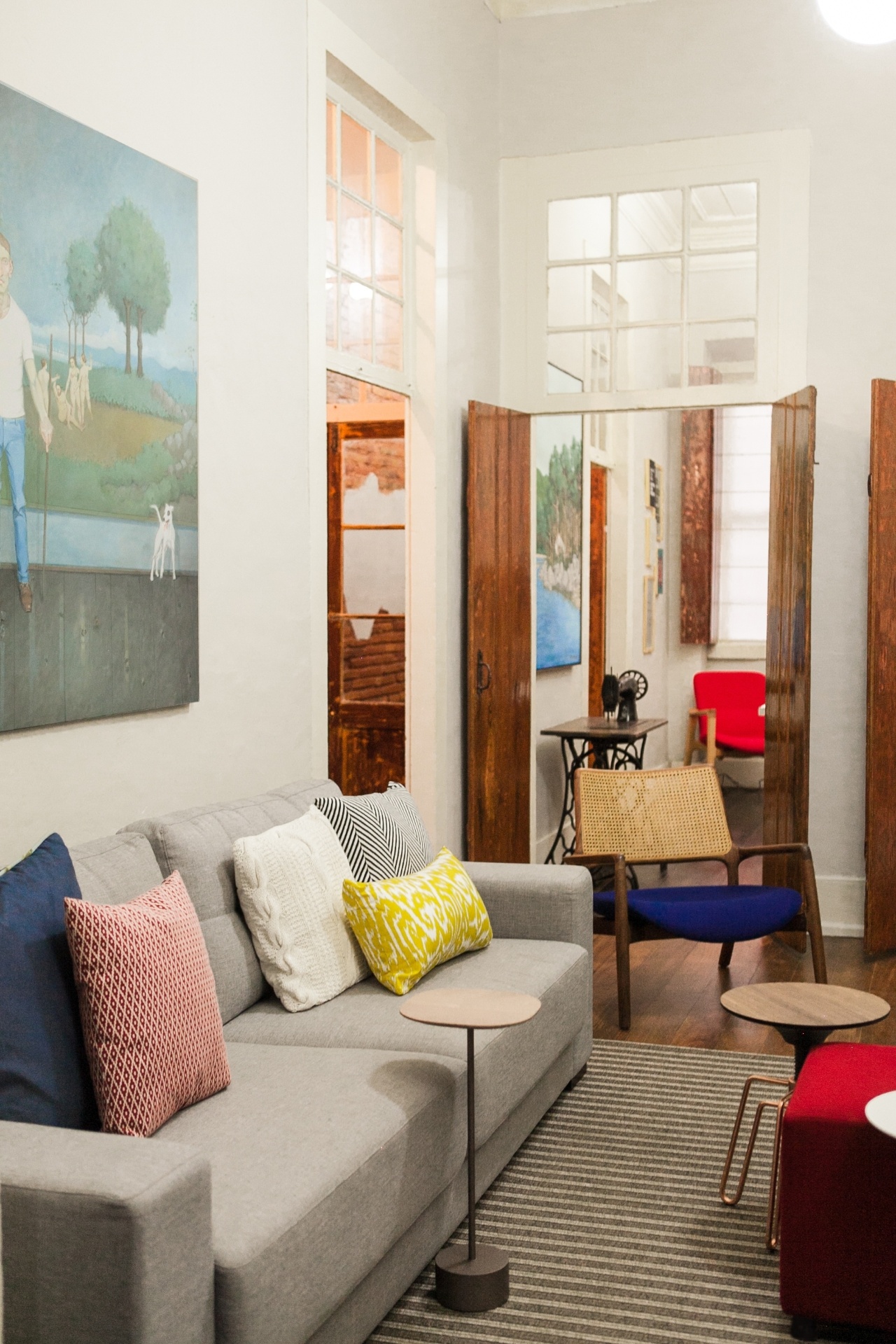 O sofá cinza ganha cor com almofadas coloridas da Objeteria. Há um cuidado ao misturar os matizes no estar, que também é home theater: os tecidos e estampas se baseiam nas padronagens geométricas e étnicas. A mesa Jardim e o banco Phillips, do designer Jader Almeida, são versáteis: podem ser usados como mesa de centro ou de apoio - Mauri Cherobin/ Divulgação