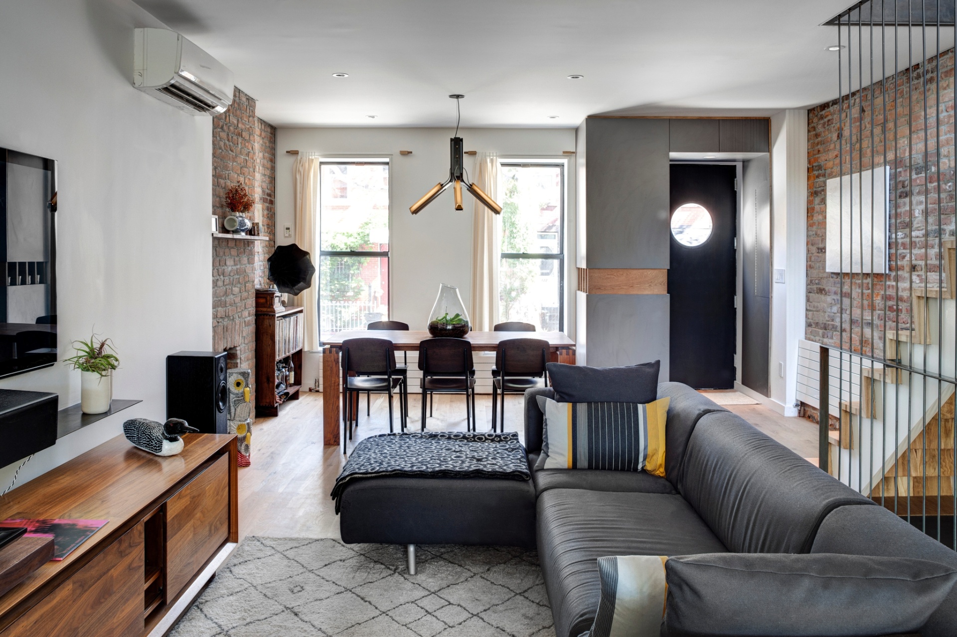 A nova sala tem pé direito alto, guarda-corpos modernos que criam uma espécie de grade junto à escada, além de sofá da Casina e mobiliário de madeira desenhado pelo proprietário da residência, Ben Krone (Imagem do NYT, usar apenas no respectivo material) - Bruce Buck/ The New York Times