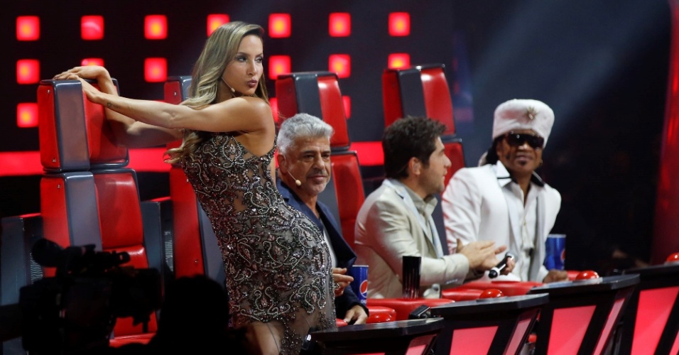 25.dez.2014 - Claudia Leitte brinca com o apresentador Tiago Leifert ao revelar vestido longo, mas decotado nas costas
