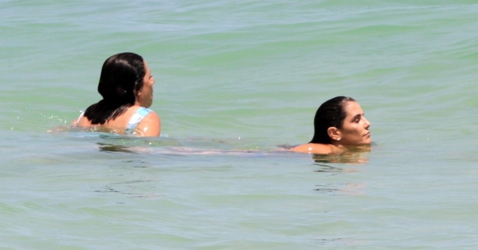 3.jan.2015 - Acompanhada da mãe, Deborah Secco mergulha na praia da Barra da Tijuca, no Rio