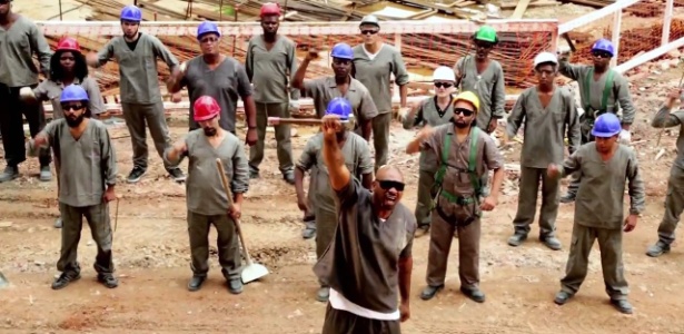 Cena do clipe da música "Brado Retumbante", de MV Bill; o rapper (á frente) canta junto com operários em uma construção - Reprodução