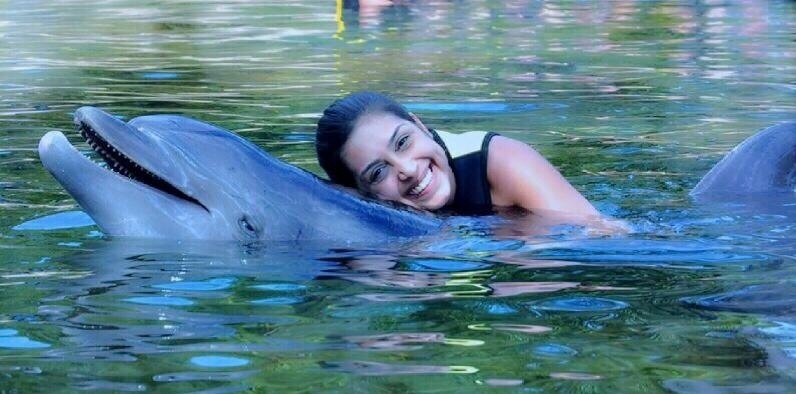 Em sua rede social, ela aparece em uma foto se divertindo com um golfinho