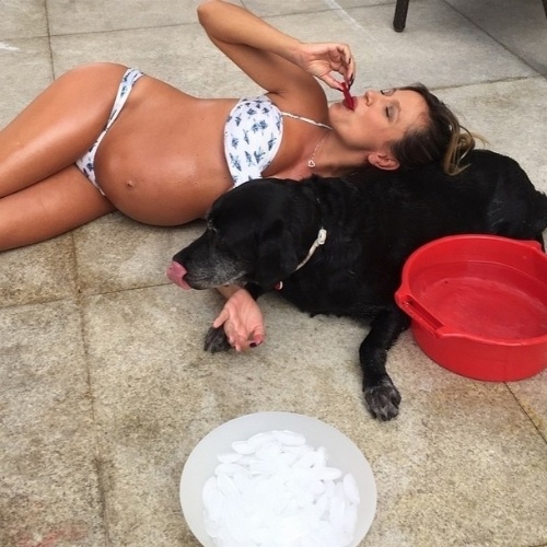19.jan.2015 -  Grávida de 8 meses, Luisa Mell mostra o barrigão de biquíni e se refresca ao lado de seu cachorro