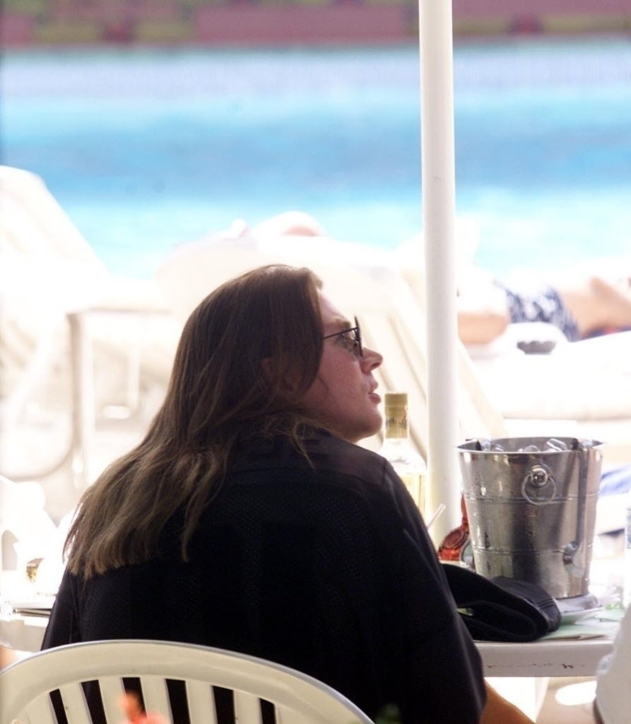 Axl Rose, vocalista do grupo Guns N' Roses, toma drinks à beira da piscina. - Reprodução