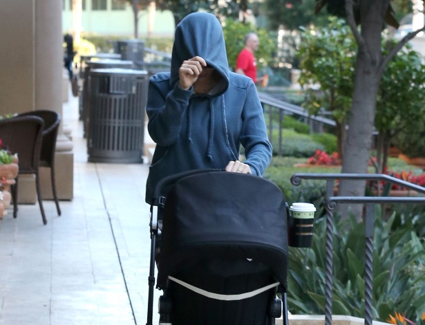 28.jan.2015 - A atriz Scarlett Johansson esconde o rosto de paparazzo ao ser fotografada em Beverly Hills (EUA) enquanto caminhava com sua filha, Rose.