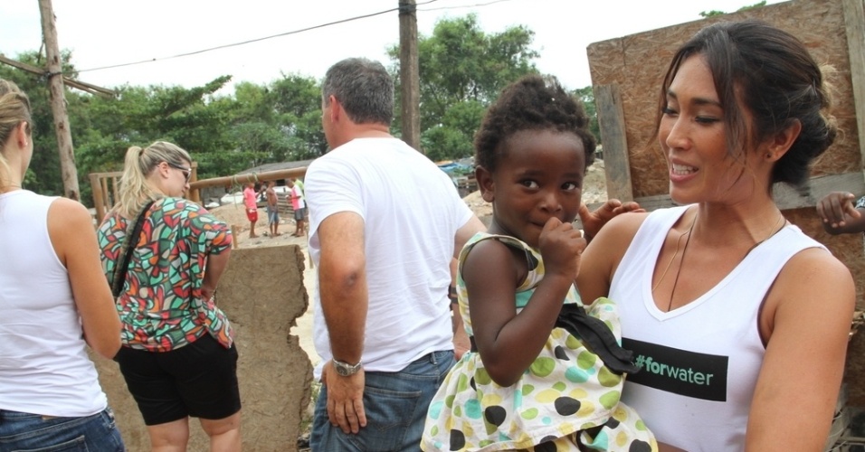 31.jan.2015 - Dani Suzuki posa com criança de Gramacho, bairro do município de Duque de Caxias