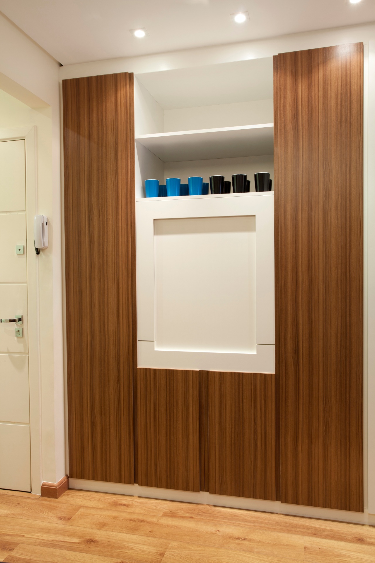 Detalhe da mesa de jantar fora de uso: sua posição fixa é embutida no louceiro, para que não obstrua a circulação entre ambientes. Como é pequena (para dois lugares), quando aberta, deixa no móvel (embutido) nichos onde podem ser colocados pratos, copos e talheres em uso (função de aparador). O casal comprou apenas duas cadeiras (Tok&Stok) para o apartamento com 32 m², reformado por Adriana Fontana - Divulgação