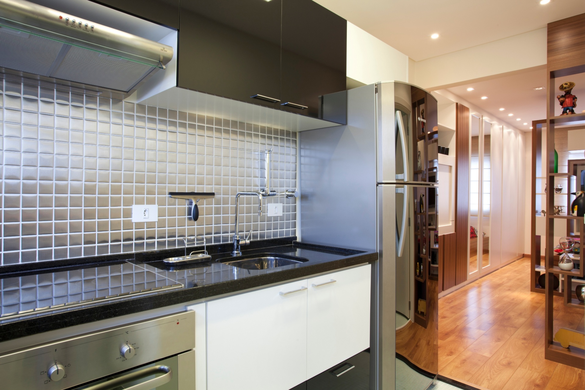 Projetado por Adriana Fontana para um casal recém-casado, o apartamento com apenas 32 m² deveria ter uma cozinha com bancada em L. O desenho dos interiores previu também um "corredor"  para a livre circulação (à dir.) que se estende de ponta a ponta no imóvel - Divulgação