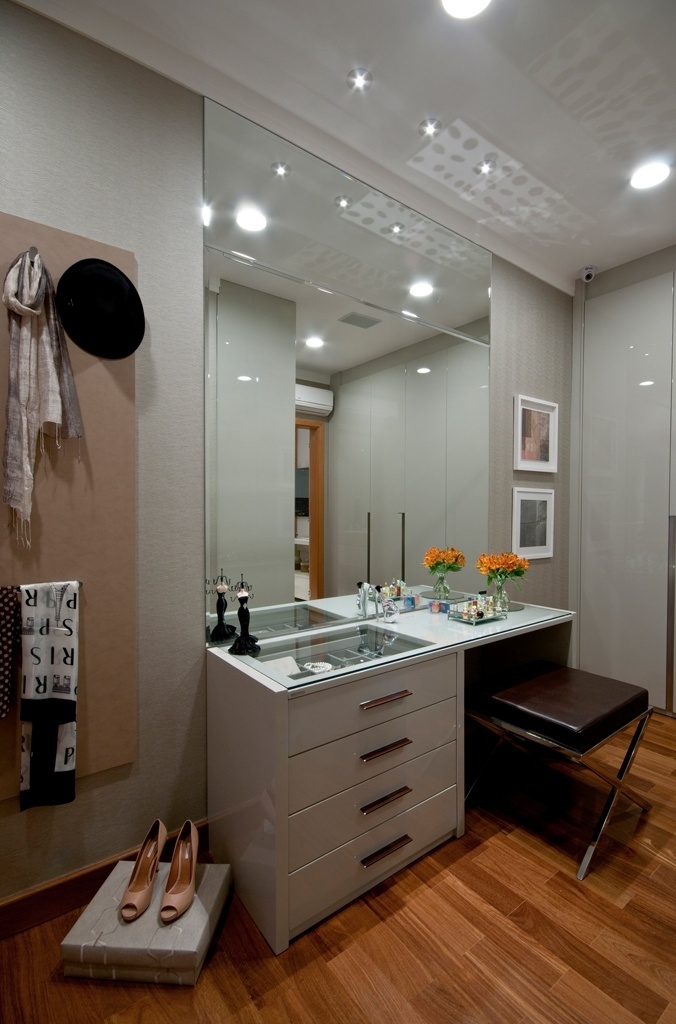 Na proposta do escritório Filomena e Vaz Arquitetura e Interiores para a Mostra Porte Decor&Arte, a penteadeira da suíte fica no closet e serve para organizar apetrechos. Executada em marcenaria (Florense), a peça tem espaço para acomodar óculos, relógios e bijuterias, além de bancada com tampo de vidro que permite a visualização dos interiores das gavetas. Um grande espelho bisotado e a banqueta arrematam o espaço com iluminação desenvolvida para não criar ofuscamentos durante a maquiagem - Henry Lopes/ Divulgação