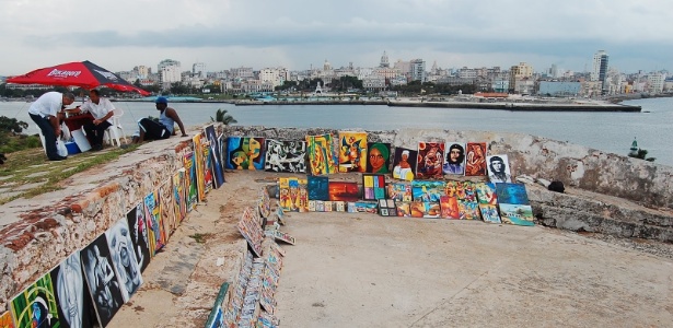 Quadros e peças de artesanato expostas em um muro com vista para Havana, em Cuba - Débora Costa e Silva/UOL