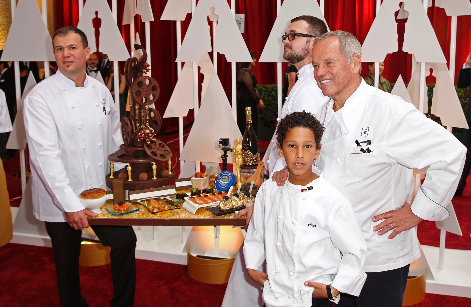 22.fev.2015 - O chef Wolfgang Puck (à direita) mostra com sua equipe suas criações para a festa após a cerimônia do Oscar 2015. O austríaco, que está acompanhado do filho Alexander Wolfgang, é famoso por seu restaurante Spago em Hollywood e por cozinhar para estrelas como Madonna, Sean Penn, Charlize Theron, entre outras - Lucas Jackson/Reuters
