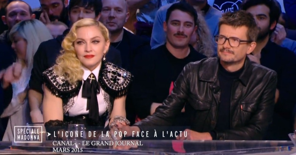 Madonna de mãos dadas com o cartunista Luz, atual editor-chefe do Charlie Hebdo, na bancada do 
