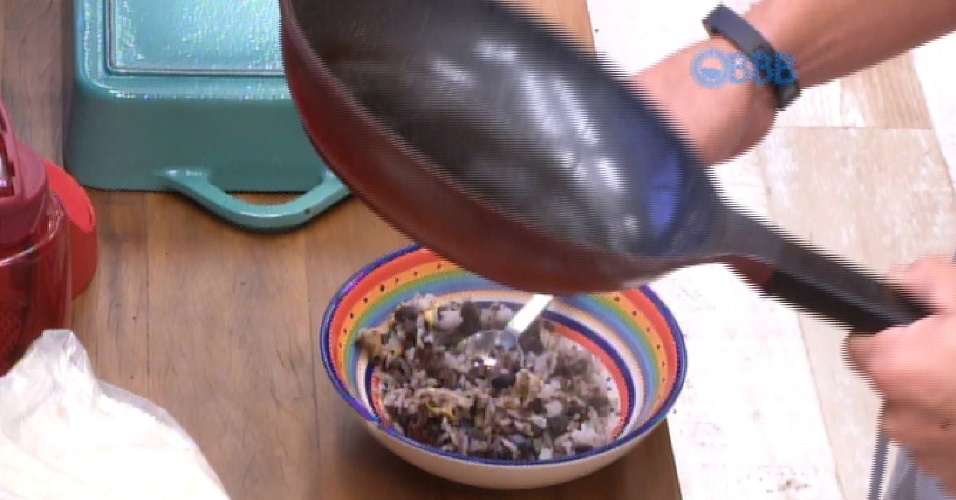 6.mar.2015 - Cézar, que nunca ganhou uma prova da comida no "BBB15", prepara seu café da manhã, composto por arroz, feijão preto e ovo