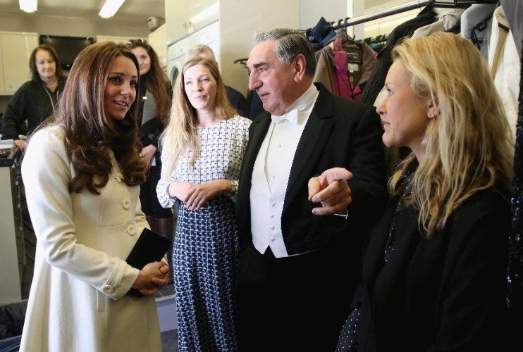 12.mar.2015 - Kate Middleton conhece o ator Jim Carter, o Carson de "Downton Abbey", durante visita ao set de gravações da série, em Londres