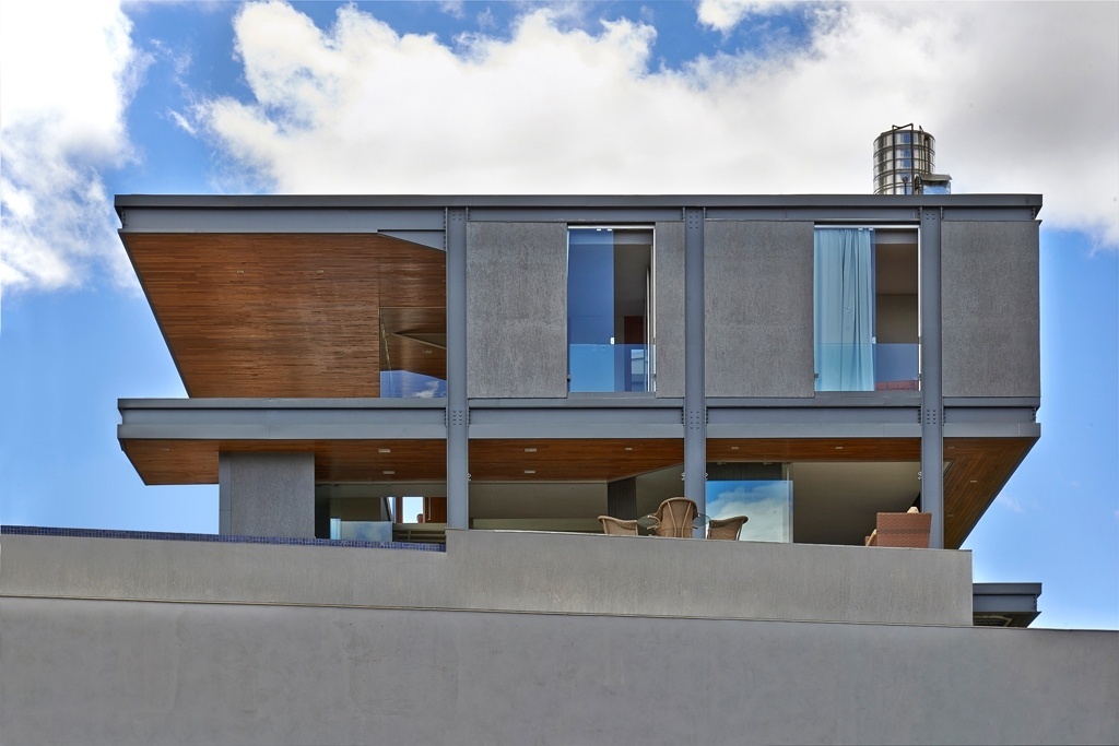 A Residência Península dos Pássaros, projetada pelos arquitetos Eduardo França e Letícia de Azevedo, está vedada para a rua, pois a frente do terreno tem declive acentuado, mas se abre para a paisagem da Lagoa dos Ingleses, em Nova Lima (MG). Piscina, cozinha e os ambientes de convivência estão em um mesmo pavimento alocado no relevo acidentado do lote - Jomar Bragança/ Divulgação