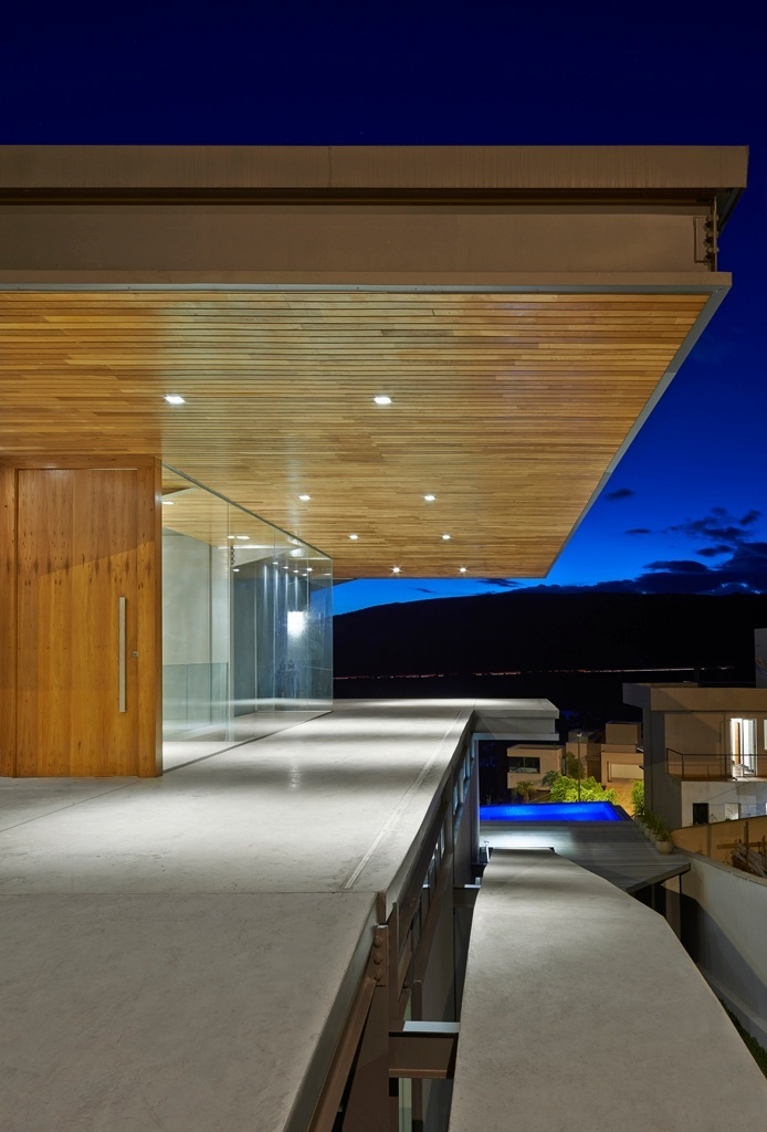 No nível da entrada, o mais alto, o espaço coberto é usado como garagem e, ao mesmo tempo, serve como marquise de proteção para o hall de distribuição. Neste mesmo patamar foram locados os cinco dormitórios. A porta e os forros são feitos em lambris de madeira ipê e os fechamentos laterais, em vidro temperado, dispensaram esquadrias - Jomar Bragança/ Divulgação