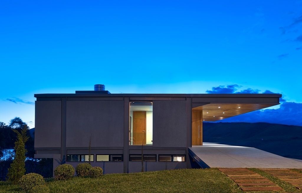 O piso das rampas de acesso foi executado com concreto polido nível zero, que é um acabamento muito liso com aparência próxima a do cimento queimado. O projeto original previa fechamentos laterais em placas cimentícias, que não receberiam qualquer revestimento. O proprietário, no entanto, optou pela aplicação de texturas (Grafiato) nas paredes da fachada. O projeto de arquitetura é assinado por Eduardo França e Letícia de Azevedo - Jomar Bragança/ Divulgação