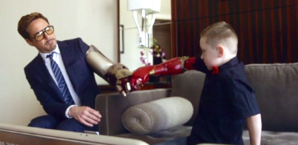 Robert Downey Jr. brinca com o garoto Alex depois de dar a ele a prótese com design da armadura do Homem de Ferro - Reprodução