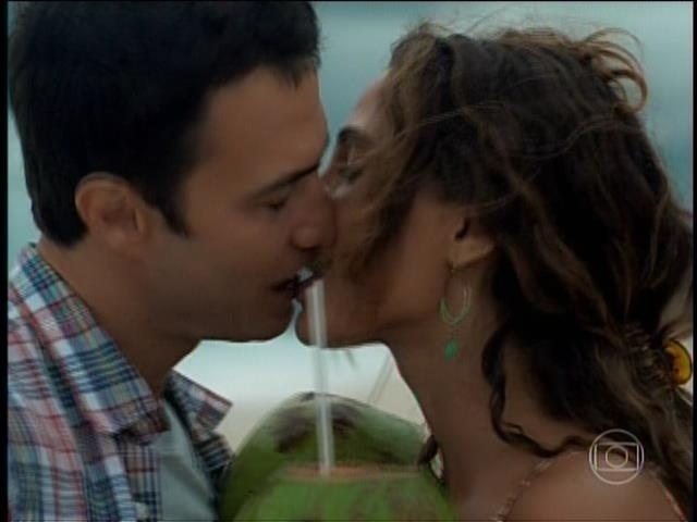 Regina e Luís se beijam na praia :"Bodas de coco. Duas semanas de namoro", diz ele antes de beijá-la