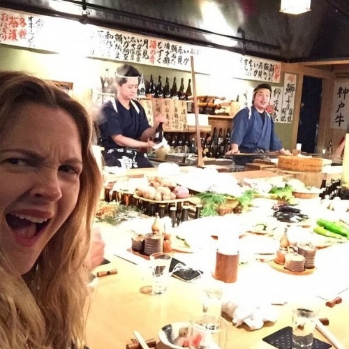 17.mar.2015 - A atriz Drew Barrymore faz careta ao tirar foto em um restaurante de Tóquio