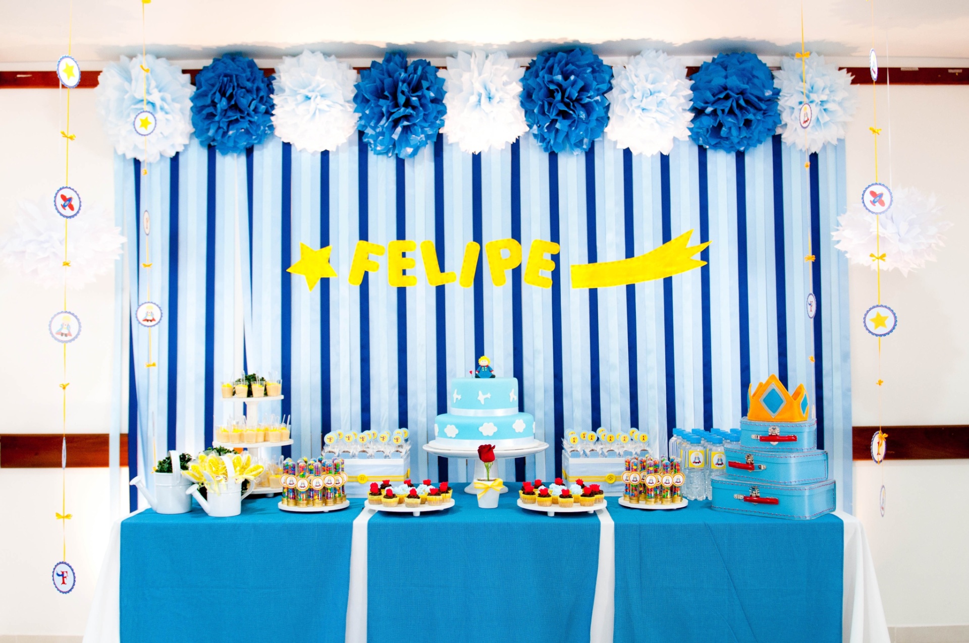 álbum com painéis para festas infantis | A decoração da festa com tema "Pequeno Príncipe", feita por Liliana Loureiro (www.lilianaloureiro.com.br), teve um painel de fitas em três tonalidades de azul, que foram presas em uma ripa de madeira e assim presas na parede. Os pompons de papel de seda foram colados com fita 3M - Vanessa Somellera/Divulgação