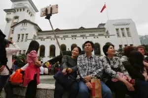 Visitantes da Casa do Governo usam pau de selfie em Hong Kong - Bobby Yip/Reuters