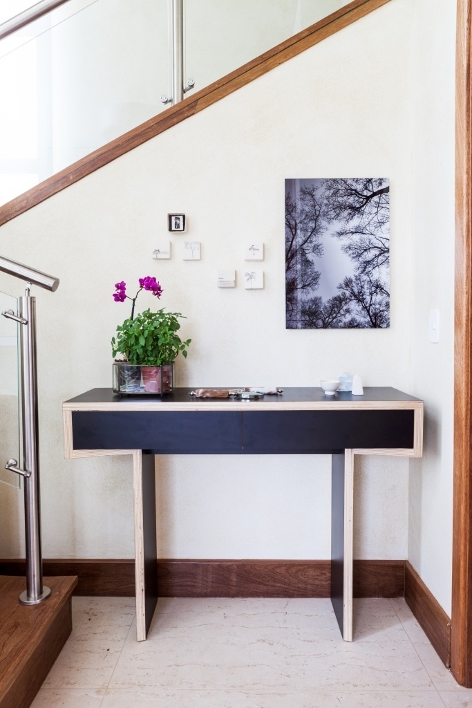 O hall de circulação foi equipado com aparador assinado pelo designer Paulo Alves e é feito de madeira reconstituída com laminado preto. Sobre a peça, composição de cerâmicas da artista Cynthia Gaviao.O projeto de decoração da casa de campo em Itu (SP) é do escritório Díptico - Lufe/ Divulgação