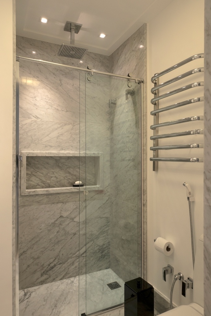 Elegante, este banheiro com apenas 3m² da Mattos Arquitetura tem cuba esculpida em mármore Carrara feita sob projeto, ?que evita bancadas profundas?, falam Fernanda e Maria Mattos. Note que o misturador monocomando posicionado na lateral da cuba também otimiza o espaço. O uso do mesmo revestimento em todo o ambiente aumenta a sensação de amplitude, "pois reduz as informações no local", explicam. Em vez de bidê, ducha higiênica e toalheiro acima do vaso aproveitam a área - Marcelo Magnani/ Divulgação