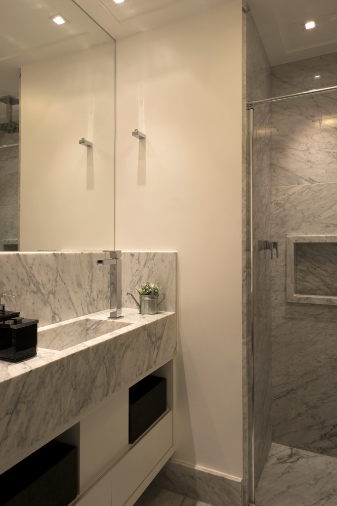 O banheiro com três metros quadrados projetado pelo escritório Mattos Arquitetura tem cuba esculpida em mármore Carrara feita sob medida e com bancada menos profunda, como esclarecem Fernanda e Maria Mattos. O posicionamento do misturador monocomando, na lateral da cuba, também economiza espaço - Marcelo Magnani/ Divulgação