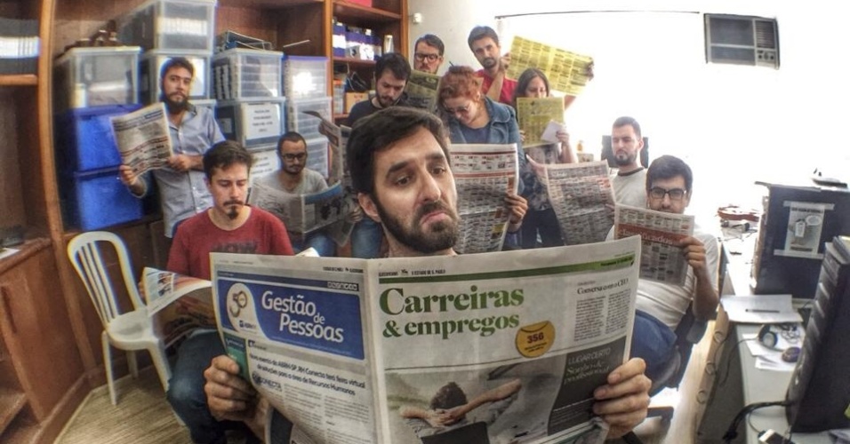 No Facebook, Rafinha Bastos publica uma foto lendo o caderno de empregos do jornal com a sua equipe ao fundo: 