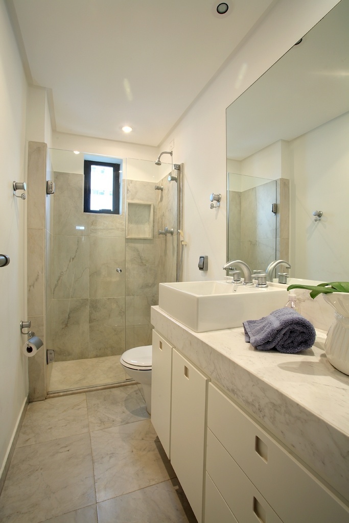 No projeto da arquiteta Karina Korn, o espaço com três metros quadrados tem o vão sob a bancada de mármore piguês aproveitado para acomodar armários. "No espaço do chuveiro, fazer nichos na alvenaria para guardar xampus e sabonetes também racionaliza a área", diz a professora da FAAP, Maria Stella Tedesco Bertaso - Nicola Labate/ Divulgação