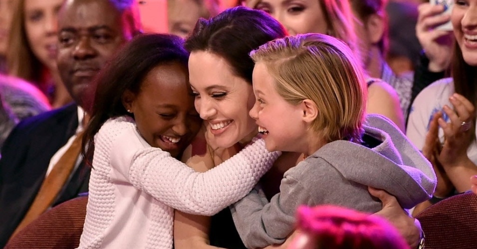 28.mar.2015 - Angelina Jolie é abraçada pelas filhas Zahara (à esq.) e Shiloh, ao vencer a categoria vilão favorito, por 
