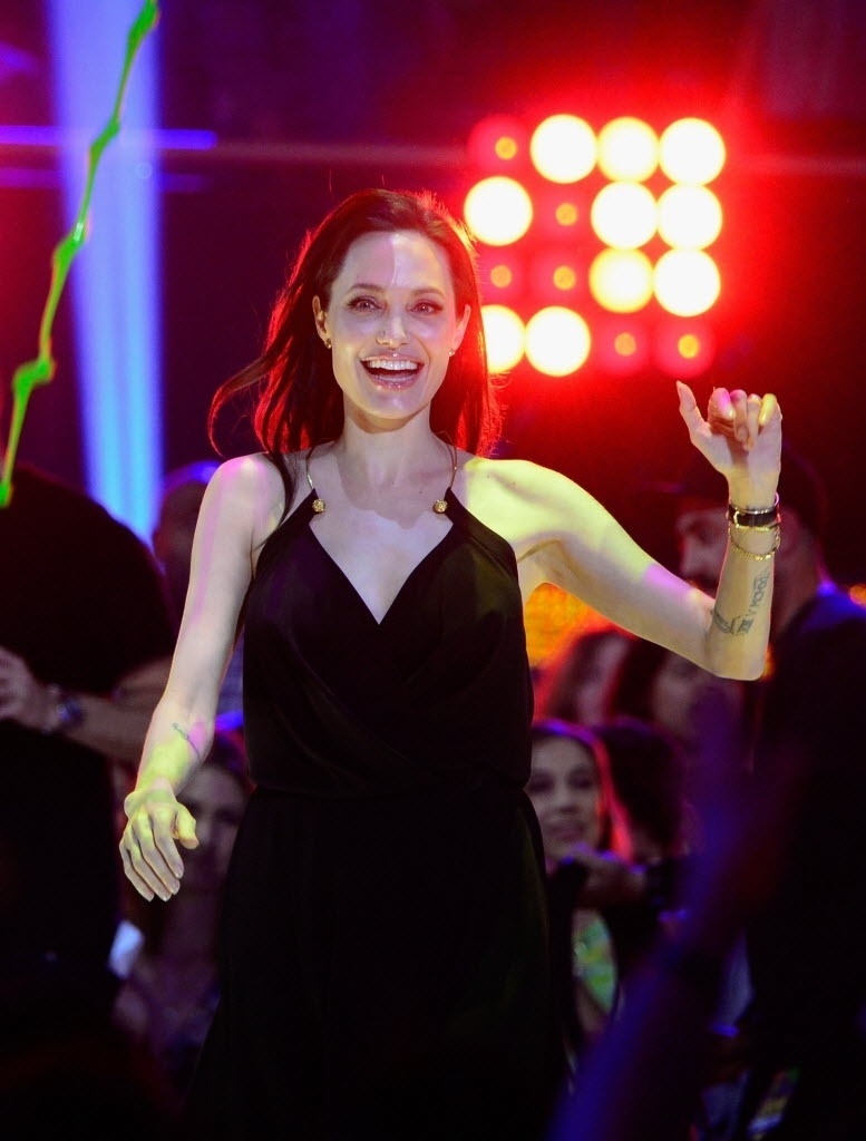 28.mar.2015 - Angelina Jolie sobe no palco do Nickelodeon Kids' Choice, em Los Angeles, para receber o prêmio de vilão favorito, por "Malévola". A atriz foi à cerimônia com as filhas Zahara e Shiloh